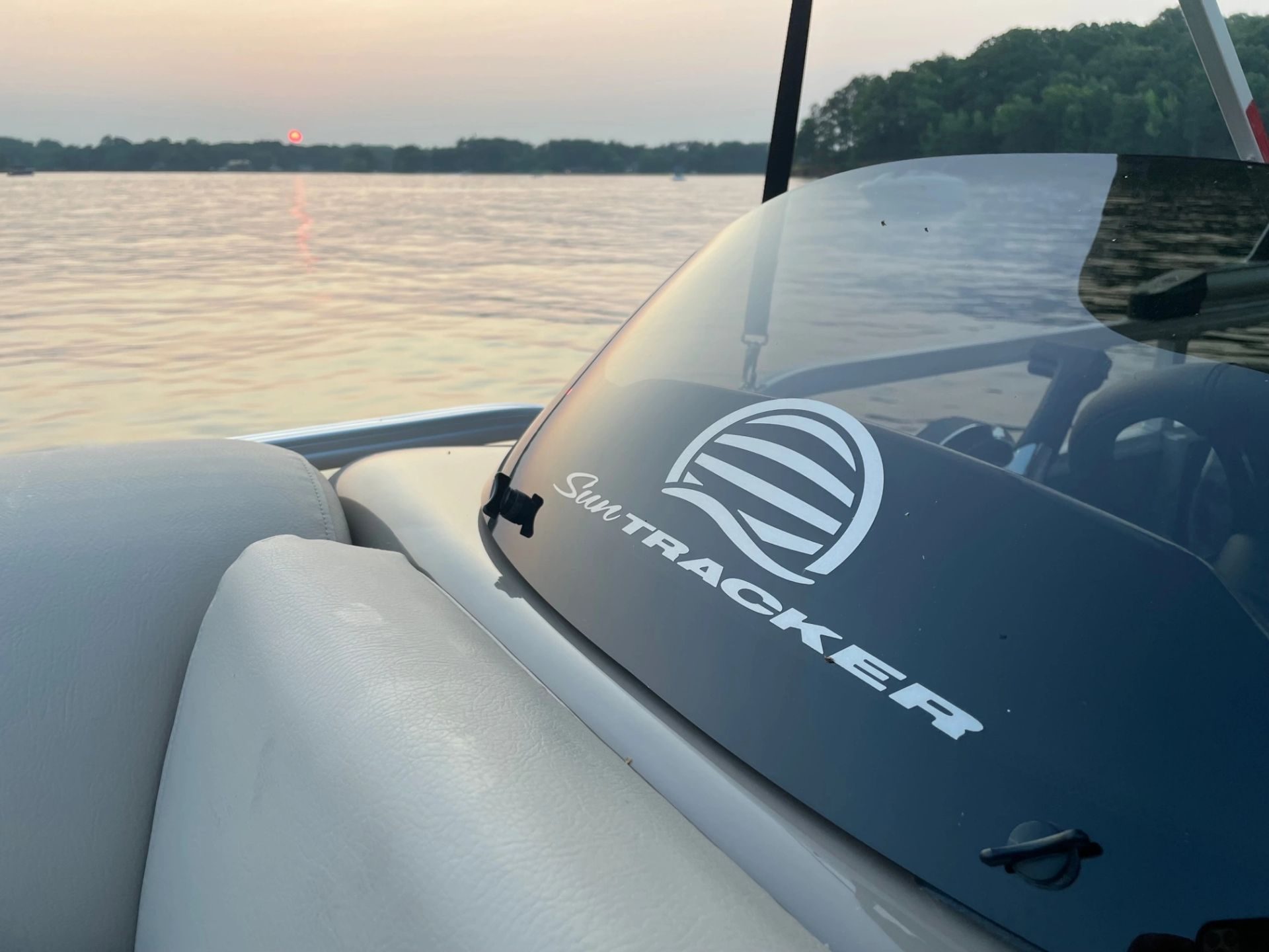 Sun Tracker windshield detail with the sunset over Lake Wylie behind it